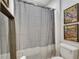 Bathroom featuring a toilet, shower and a gray and white curtain with comic book art pieces hung on the wall at 10399 Boyette Brook St, Riverview, FL 33569