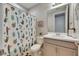 Bathroom with a gray vanity, toilet, and a decorative cactus-themed shower curtain at 10399 Boyette Brook St, Riverview, FL 33569