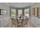 Cozy breakfast nook with a round table, six chairs, and a bay window overlooking the backyard at 10399 Boyette Brook St, Riverview, FL 33569