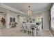 Formal dining room with chandelier, wood-look floors, and views into the open kitchen and staircase at 10399 Boyette Brook St, Riverview, FL 33569