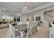 Open concept dining room with chandelier, wood-look floors, and views to the living room and staircase at 10399 Boyette Brook St, Riverview, FL 33569
