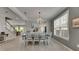 Bright dining room with wainscotting detail, wood-look floors, and views to the staircase and open floorplan at 10399 Boyette Brook St, Riverview, FL 33569