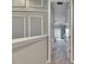 Upstairs hallway features neutral carpet, gray walls with decorative trim, and a view to the main bedroom with balcony at 10399 Boyette Brook St, Riverview, FL 33569