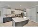 Modern kitchen boasts a large island, stainless steel appliances, and sleek gray and white cabinetry at 10399 Boyette Brook St, Riverview, FL 33569