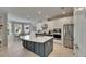 Bright kitchen showcases white cabinets, a large island, stainless steel appliances, and a sunlit breakfast nook at 10399 Boyette Brook St, Riverview, FL 33569