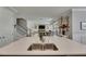 Kitchen island featuring a double sink and views into the living room and staircase, ideal for entertaining at 10399 Boyette Brook St, Riverview, FL 33569