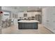 Modern kitchen featuring white cabinets, a contrasting island, stainless steel appliances, and an adjacent dining area at 10399 Boyette Brook St, Riverview, FL 33569