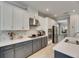 Modern kitchen featuring white cabinets, stainless steel appliances, and a stylish backsplash, perfect for cooking at 10399 Boyette Brook St, Riverview, FL 33569