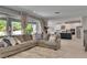 Bright, open living room boasts a gray sectional, neutral decor, and seamless transition into a modern kitchen at 10399 Boyette Brook St, Riverview, FL 33569