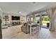 Bright living room with sliding glass doors, wood-look floors, and a mounted television at 10399 Boyette Brook St, Riverview, FL 33569