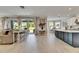 Open concept living space with bar seating, sliding glass doors to the patio, and open kitchen views at 10399 Boyette Brook St, Riverview, FL 33569