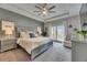 A spacious main bedroom with tray ceiling, ceiling fan, balcony access, and a king-sized bed at 10399 Boyette Brook St, Riverview, FL 33569