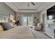 Well-lit main bedroom boasts tray ceilings, a king bed, balcony access, and stylish gray furniture at 10399 Boyette Brook St, Riverview, FL 33569