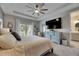 Main bedroom with tray ceiling, fan, large TV, balcony access, and an ensuite bathroom at 10399 Boyette Brook St, Riverview, FL 33569