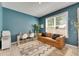 Bright home office features a stylish sofa, large window, and a unique rug at 10399 Boyette Brook St, Riverview, FL 33569