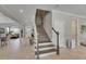 Elegant staircase with carpeted steps, gray wood accents, and bright lighting, offering a welcoming entry space at 10399 Boyette Brook St, Riverview, FL 33569
