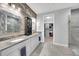 Modern bathroom with dual sinks, granite countertops, decorative wood paneling and updated shower at 10450 Highland Park Pl, Palmetto, FL 34221