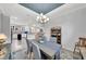 View of the elegant dining room and open-plan kitchen, featuring a modern chandelier and neutral color palette at 10450 Highland Park Pl, Palmetto, FL 34221