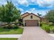 Charming single Gathering home featuring lush landscaping and a brick driveway and a two-car garage at 10450 Highland Park Pl, Palmetto, FL 34221