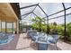 Enjoy outdoor dining and relaxing on this enclosed patio with a dining set and comfortable sofa at 10450 Highland Park Pl, Palmetto, FL 34221