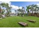 Outdoor recreation area with cornhole game, seating, and lush landscaping at 10450 Highland Park Pl, Palmetto, FL 34221