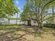 A spacious backyard with mature trees, a chain link fence and a storage building at 111 E Early St, Brooksville, FL 34601