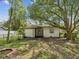 A spacious backyard with mature trees, a chain link fence and a storage building at 111 E Early St, Brooksville, FL 34601