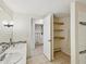 Bathroom featuring dual sinks, open shelves, and a door leading to the water heater at 111 E Early St, Brooksville, FL 34601