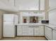 Bright kitchen featuring white cabinets and tile countertops in a well-lit home with fireplace views at 111 E Early St, Brooksville, FL 34601