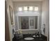 Well-lit bathroom with granite countertop, updated fixtures, and vanity with storage, and a large mirror at 12133 Spartan Way # 203, Hudson, FL 34667