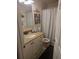 Cozy bathroom featuring granite countertops, white cabinets, and a shower with a striped curtain at 12133 Spartan Way # 203, Hudson, FL 34667