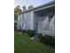 Exterior view of a two-story condo featuring gray walls, white trim, a small yard and access stairs at 12133 Spartan Way # 203, Hudson, FL 34667