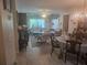 Open floor plan of living and dining room with hardwood floors, ceiling fan, and natural lighting at 12133 Spartan Way # 203, Hudson, FL 34667