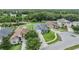 Aerial view of a neighborhood highlighting a home with solar panels, a pond, and lush surrounding landscape at 12251 Duckett Ct, Spring Hill, FL 34610