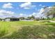Lush backyard with a tranquil pond view and neighboring homes, creating a serene and inviting outdoor space at 12251 Duckett Ct, Spring Hill, FL 34610