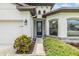 Close-up of entrance and front yard featuring manicured shrubs and a glass front door at 12251 Duckett Ct, Spring Hill, FL 34610