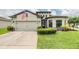 Beautiful house featuring a two-car garage, well-maintained lawn, and inviting curb appeal at 12251 Duckett Ct, Spring Hill, FL 34610