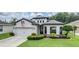 Charming single-Gathering home featuring a well-manicured lawn, mature landscaping, and an attached two-car garage at 12251 Duckett Ct, Spring Hill, FL 34610