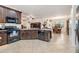 Open concept kitchen featuring granite counters, tile floors, an island with a sink, and an open view to the dining and living rooms at 12251 Duckett Ct, Spring Hill, FL 34610