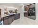 Open concept kitchen featuring granite counters, tile floors, an island with a sink, and an open view to the dining and living rooms at 12251 Duckett Ct, Spring Hill, FL 34610