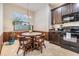 Eat in kitchen with dark cabinets, granite counters, and stainless steel appliances, and a window that overlooks the front yard at 12251 Duckett Ct, Spring Hill, FL 34610