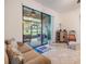 Cozy living room featuring tile floors, neutral paint, and a sliding glass door leading to the screened in porch at 12251 Duckett Ct, Spring Hill, FL 34610