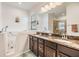 Primary bathroom with double sink granite vanity, large mirror, and handicap-accessible jacuzzi tub at 12251 Duckett Ct, Spring Hill, FL 34610