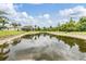 Scenic view of the property featuring a serene pond reflecting the sky and lush greenery, adding tranquility at 12251 Duckett Ct, Spring Hill, FL 34610