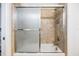 A clean bathroom with a bathtub and shower, featuring sleek glass doors and tiled walls at 12251 Duckett Ct, Spring Hill, FL 34610