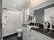 Modern bathroom featuring a glass shower, granite countertop, and white cabinets at 12603 Corral Rd, Tampa, FL 33626