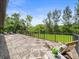 Outdoor deck with wood tile, iron railings, and views of lush green trees at 12603 Corral Rd, Tampa, FL 33626