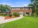 Charming brick home with lush landscaping, a brick walkway, and manicured lawn at 12603 Corral Rd, Tampa, FL 33626