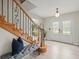 Welcoming foyer with a wooden staircase, decorative glass front doors, and a comfortable bench at 12603 Corral Rd, Tampa, FL 33626