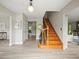 Bright foyer with wooden staircase, gray accent wall, and new vinyl flooring at 12603 Corral Rd, Tampa, FL 33626